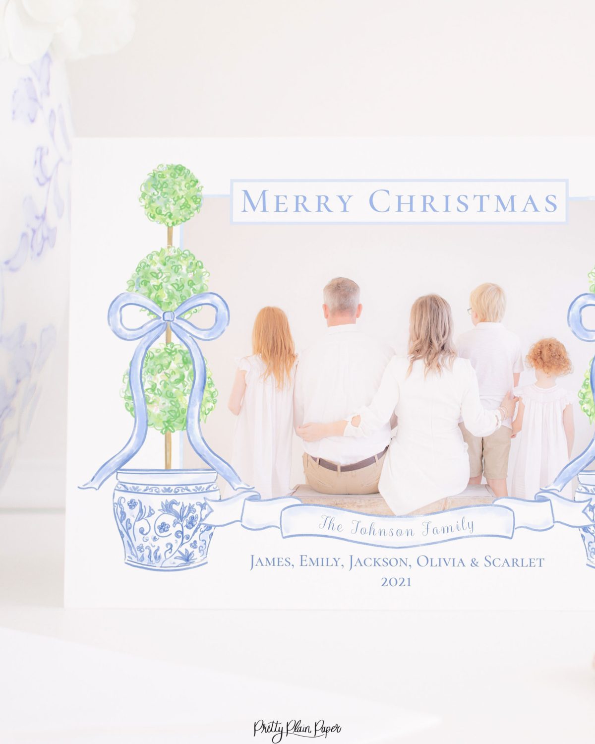 Watercolor Christmas Card with Photo by Pretty Plain Paper a Grandmillennial Christmas Card with Chinoiserie Topiaries and Blue Bows